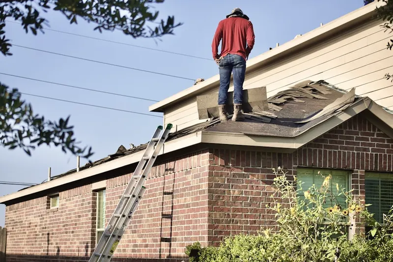 Professional roofer working on a residential roof in Rasbach Corner